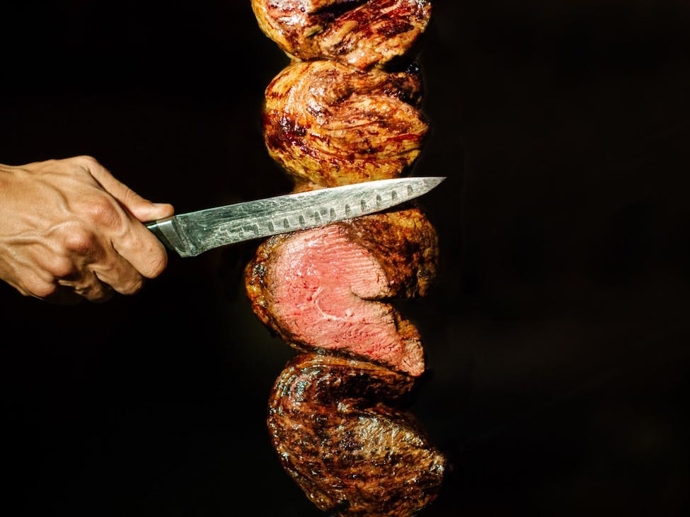 Carving a meat on a stick.