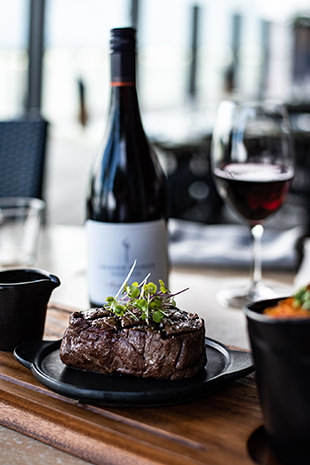 Steak and red wine bottle and glass at Dundee's Waterfront