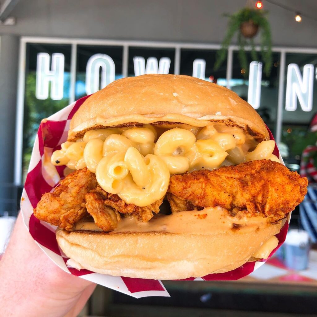 Secret menu item, mac n cheese burger showcased in front of their neon signs