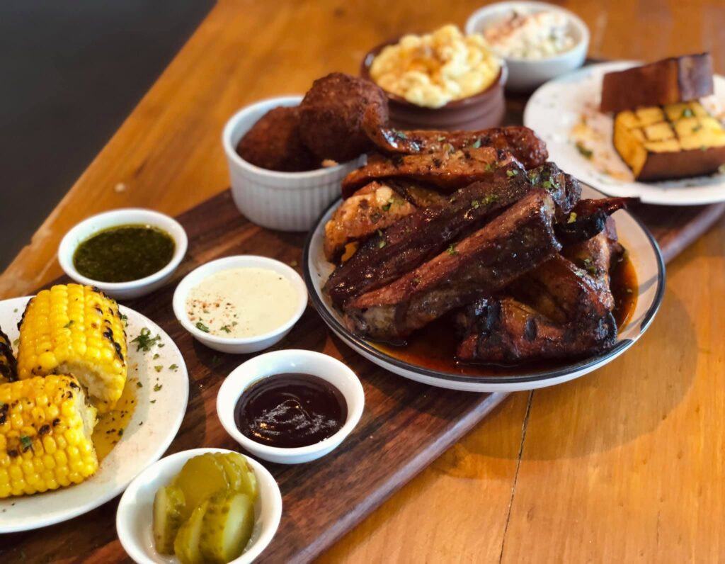 Slap and Pickle platter with brisket, pulled pork, ribs, pork sausage, bread rolls, and more.